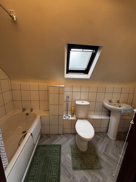 Bathroom with bath, basin and skylight